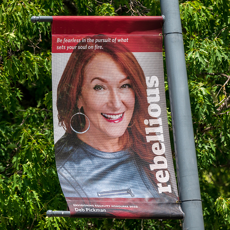 Deb Pickman pictured on a red banner