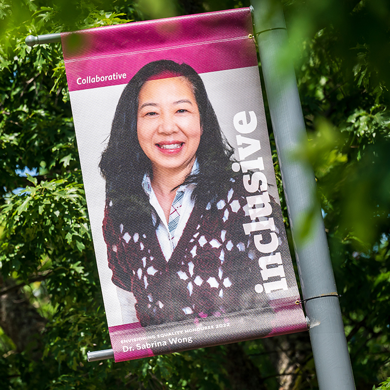 Dr. Sabrina Wong, pictured on a magenta banner