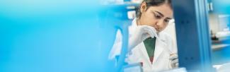 A technician in a laboratory works with a pipette and a test tube