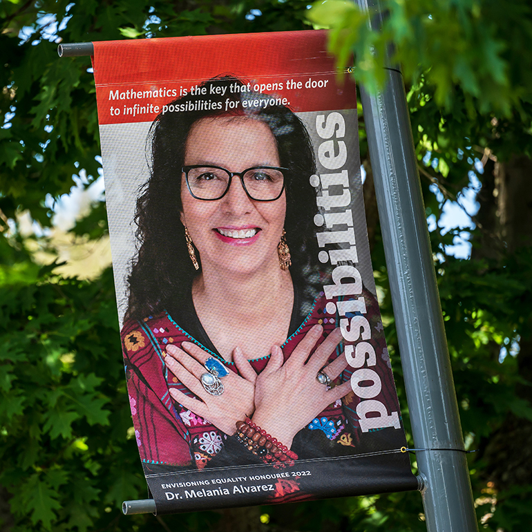 Dr. Melania Alvarez, pictured on a red banner.
