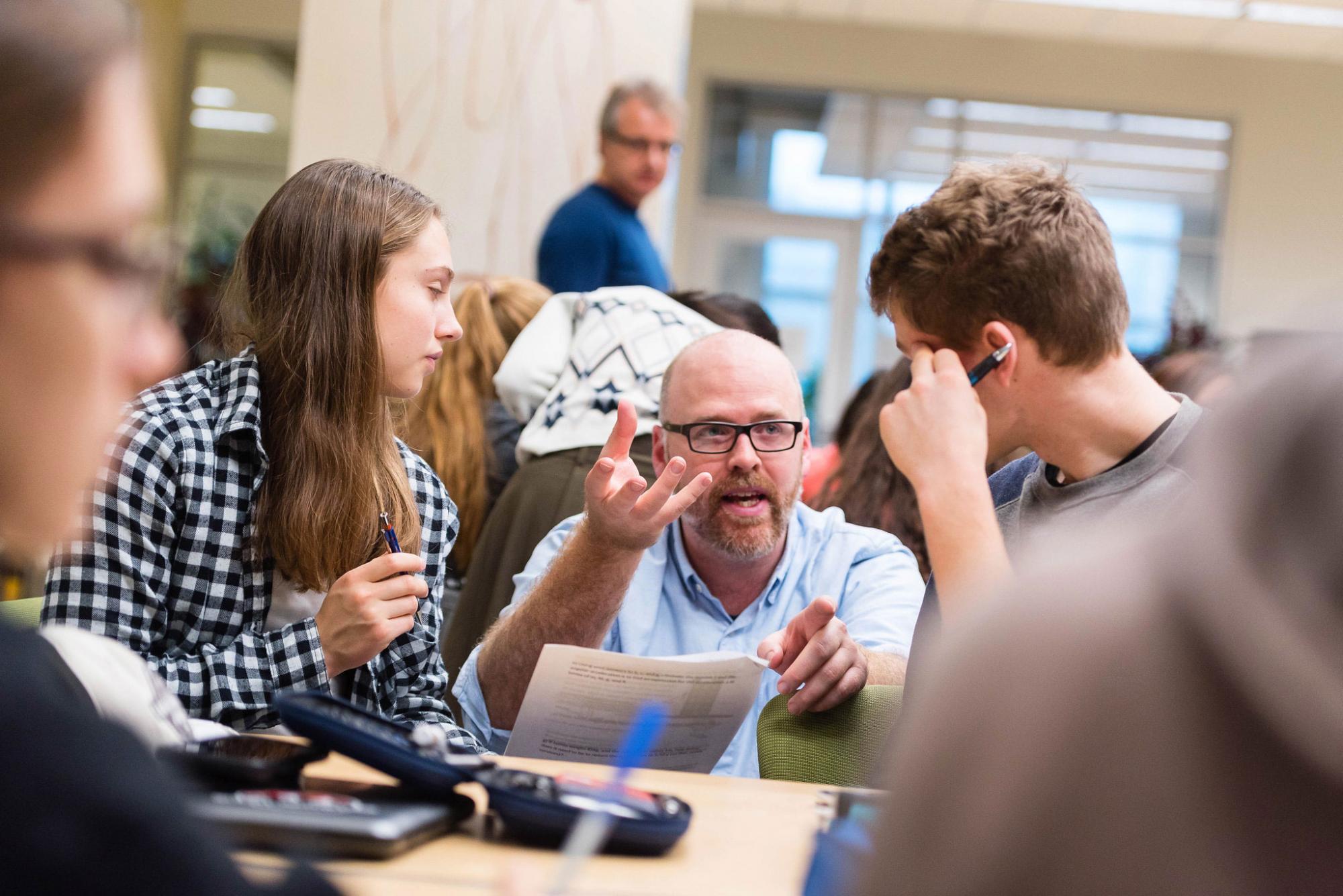 Dr. James Charbonneau, Associate Professor of Teaching in the Department of Physics and Astronomy, in a Science One Classroom, speaking with two students.